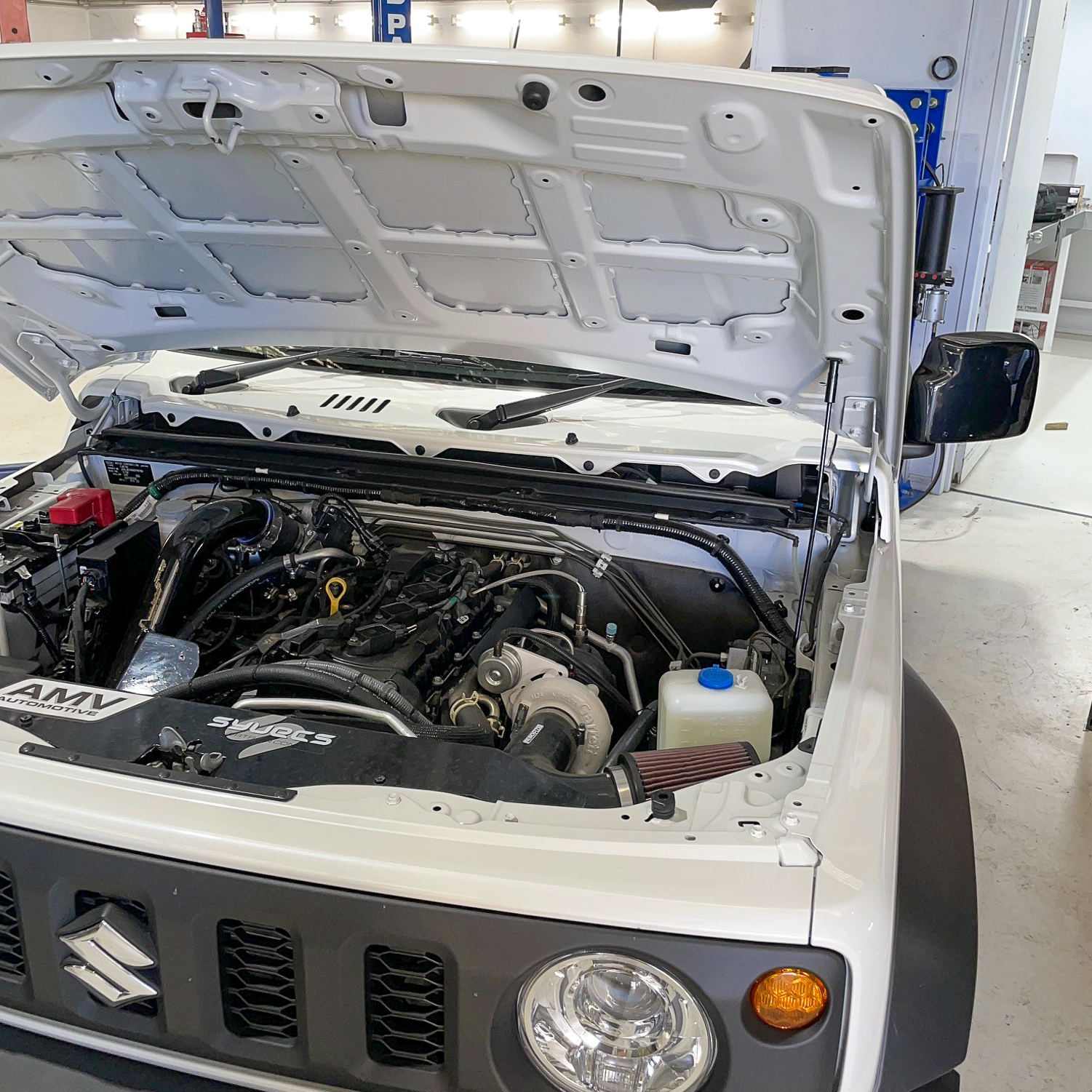 Superior White Suzuki Jimny JB74 engine bay with an AMV Garret Motion Turbo kit fitted