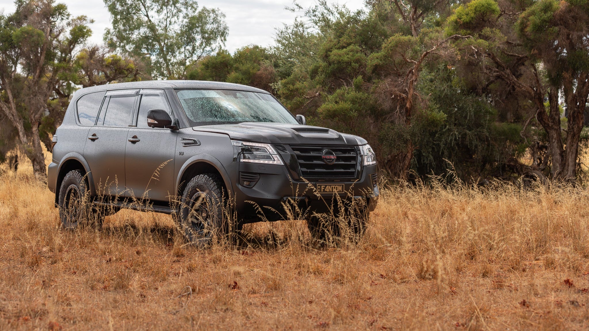 Nissan Y62 with blacked out badges, carbon fibre bonnet, Manta Performance exhaust, Harrop TVS2300 supercharger, Maxxis Razr AT tyres, Dirty Life wheels, wood grain delete, EVC throttle controller, AMV slimline flairs, AMV Suspension lift, AMV custom multimap tune. 