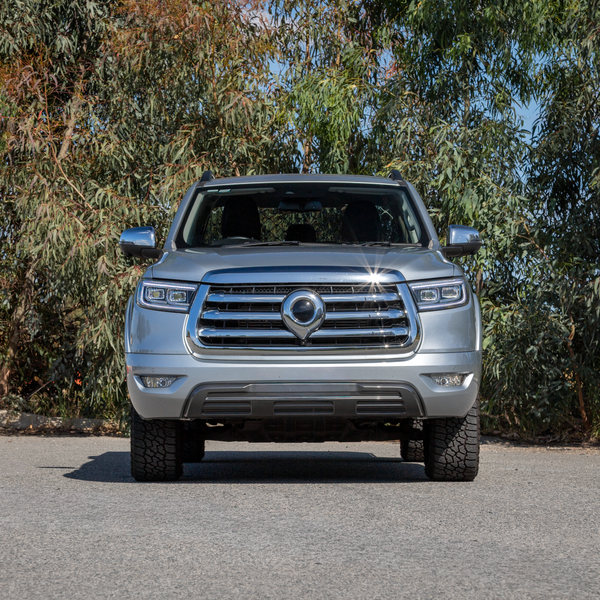 Front view of a GWM Cannon Ute parked in front of green leafy backdrop