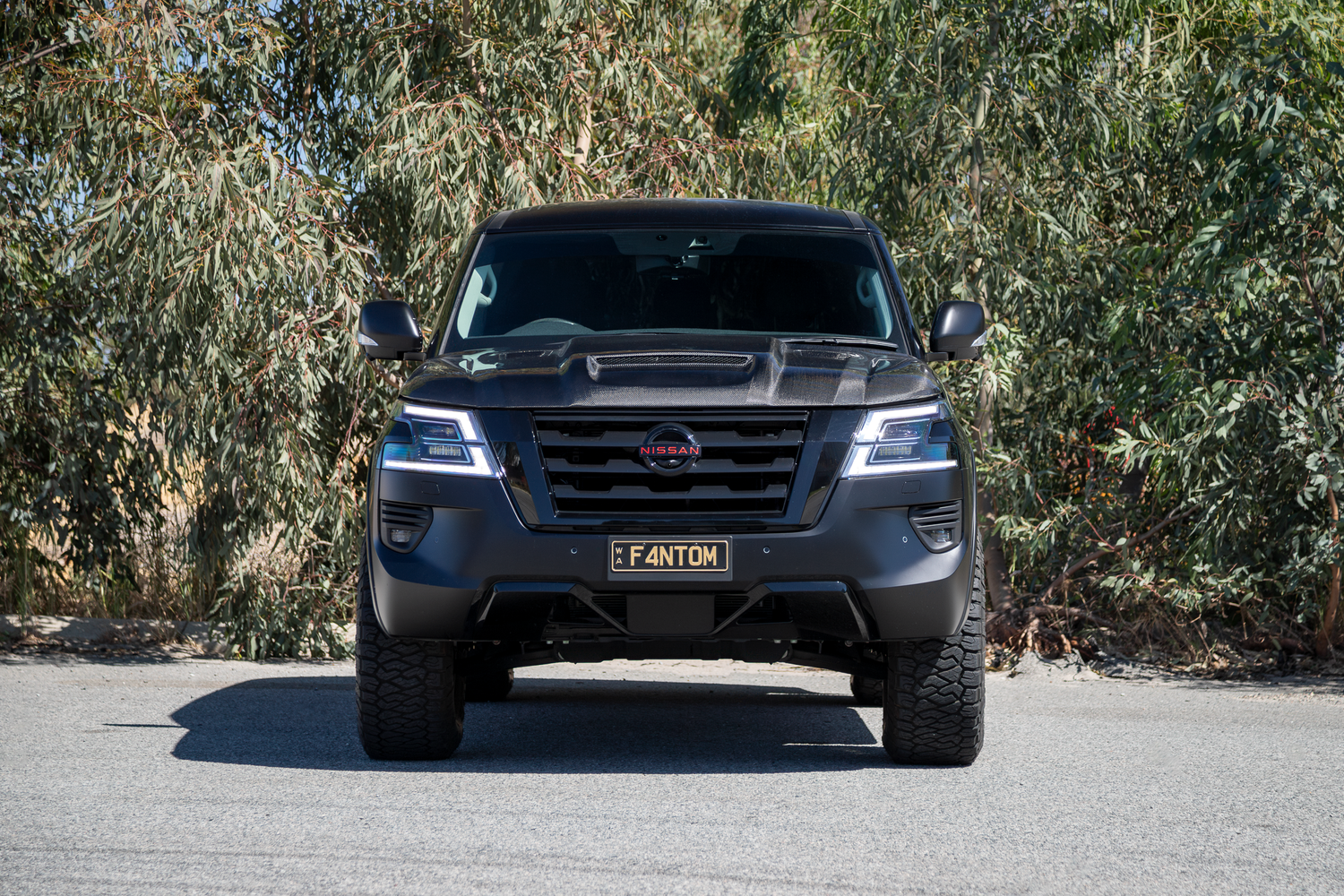 Nissan Y62 with blacked out badges, carbon fibre bonnet, Manta Performance exhaust, Harrop TVS2300 supercharger, Maxxis Razr AT tyres, Dirty Life wheels, wood grain delete, EVC throttle controller, AMV slimline flairs, AMV Suspension lift, AMV custom multimap tune. 