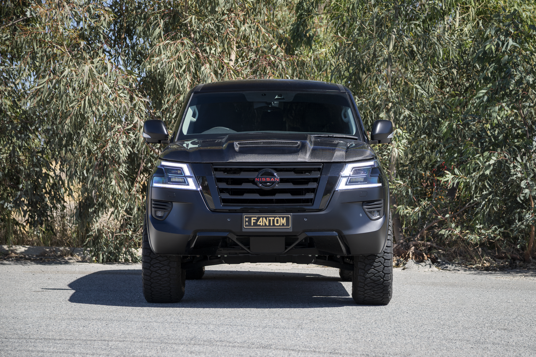 Nissan Y62 with blacked out badges, carbon fibre bonnet, Manta Performance exhaust, Harrop TVS2300 supercharger, Maxxis Razr AT tyres, Dirty Life wheels, wood grain delete, EVC throttle controller, AMV slimline flairs, AMV Suspension lift, AMV custom multimap tune. 