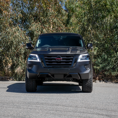 Front view of black Nissan Y62 with blacked out badges and a carbon fibre bonnet.